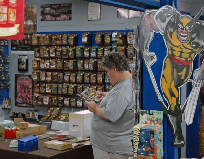 Man reading comic book inside Fats Comics &amp; Collectables in Annerley