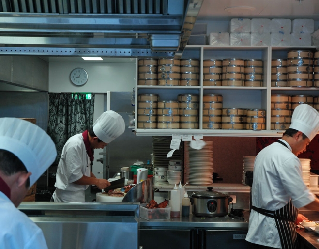 Chinese chef in kitchen seen through window on the street 