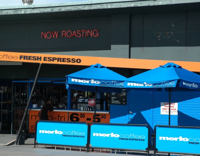 Umbrellas and seating outside Merlo Terraferzone with people sipping coffee in Brisbane's  Paddington