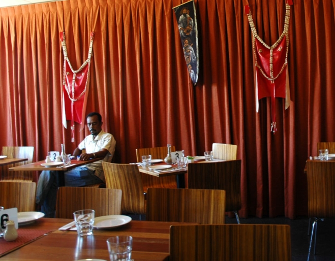 African man sitting inside Mu’ooz Eritran Restaurant Moorooka