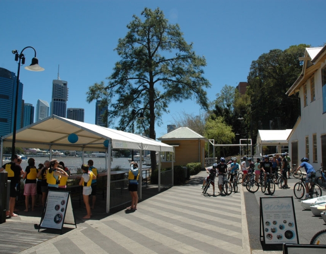People on bikes and getting ready to canoe on Brisbane River next to Riverlife Adventure Centre in Kangaroo Pt