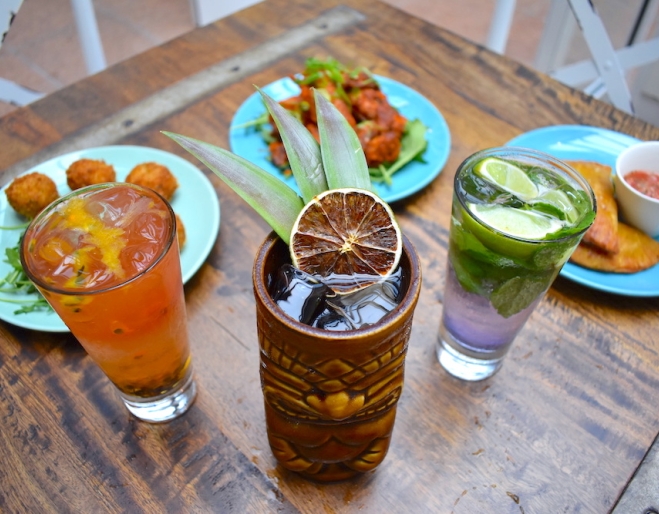 Drinks in glasses and three plates of food at Barbossa Bar & Bottleshop