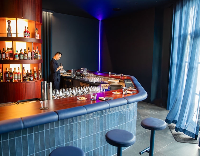Bartenders standing behind bar in +81 Aziome Bar