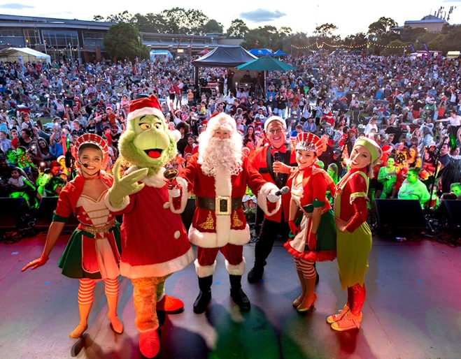 Crowd watching characters on stage Christmas Carols Logan