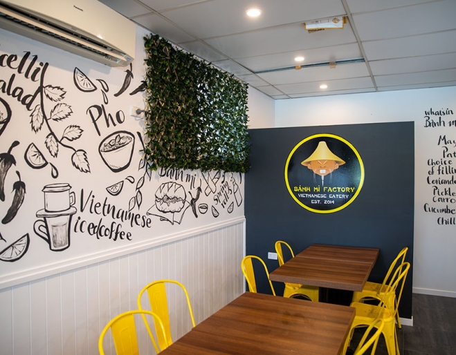 Yellow chairs with brown wooden tables inside Banh Mi Factory Zillmere