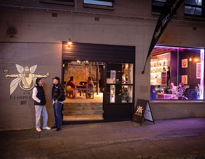 People outside Bar Mesopotamia by night