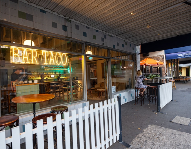 Tables outside and street entry of Bar Taco
