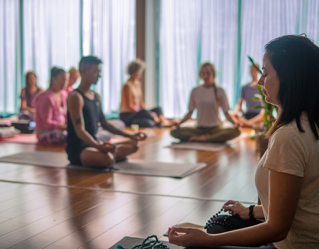 woman leading a group of people meditating