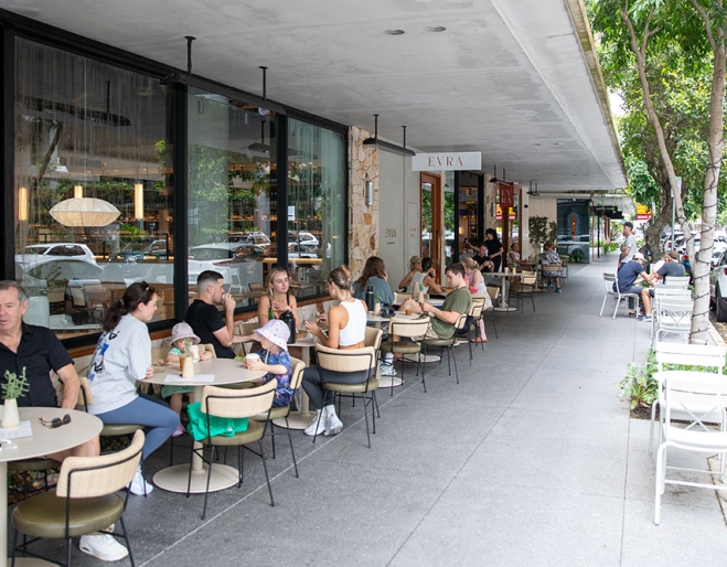 People sitting at tables outside Evra Marketplace