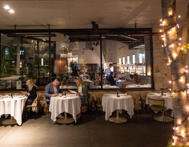 People seated at tables outside Evra Newstead