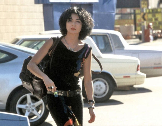 Woman walking next to cars in Maggie Cheung Clean 2004 at the GOMA Hong Kong Cinema