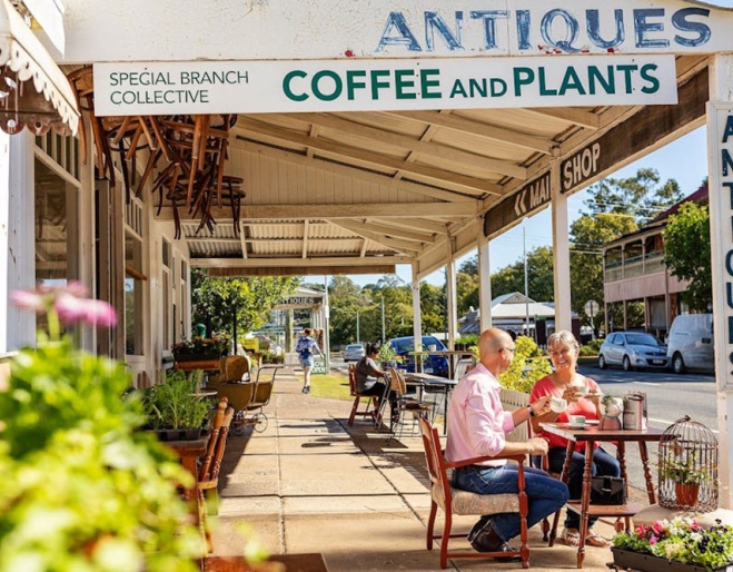 Streetscape of Marburg with a couple sitting at table on footpath