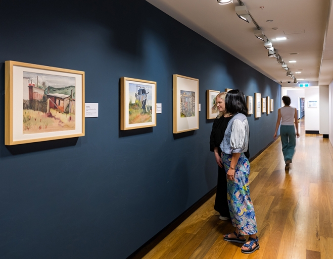 People looking at Cribb Island: Brisbane's Lost Suburb Exhibition at Museum of Brisbane