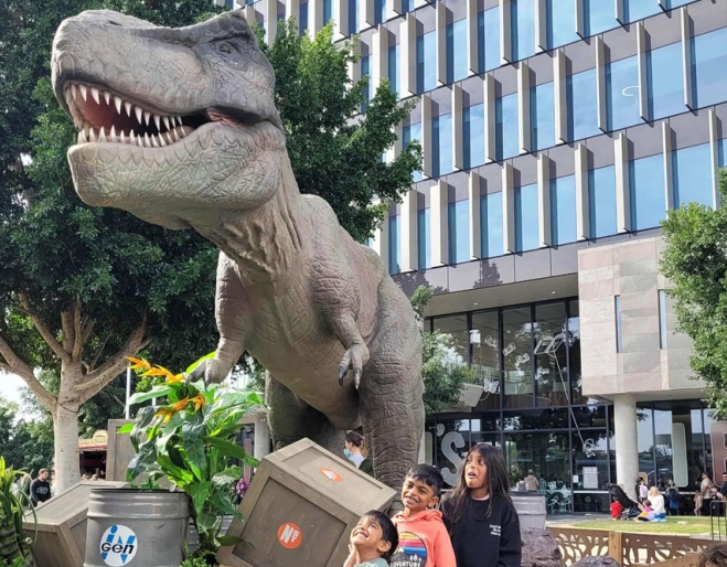 Family posing for a picture with a dinosuar