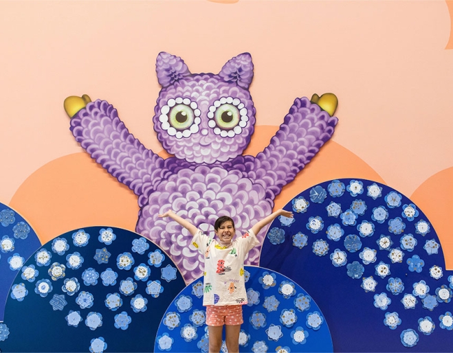 Child standing in front of artwork GOMA