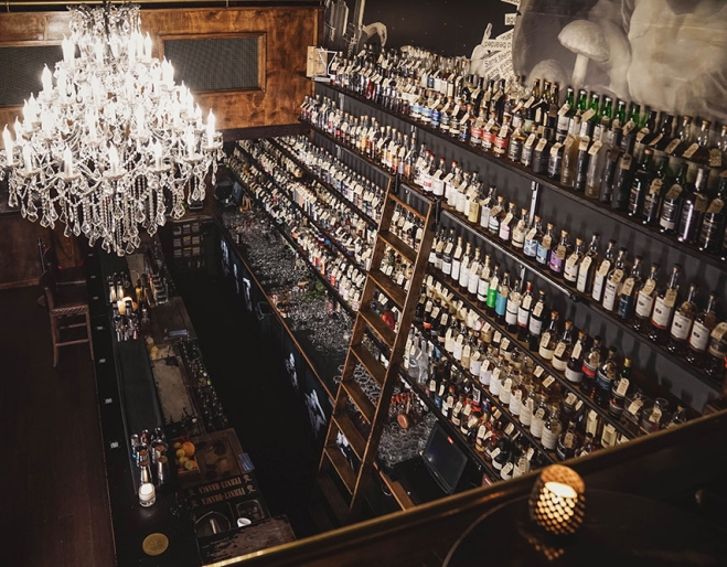 Chandelier and alcohol bottles on walls at Savile Row Fortitude Valley