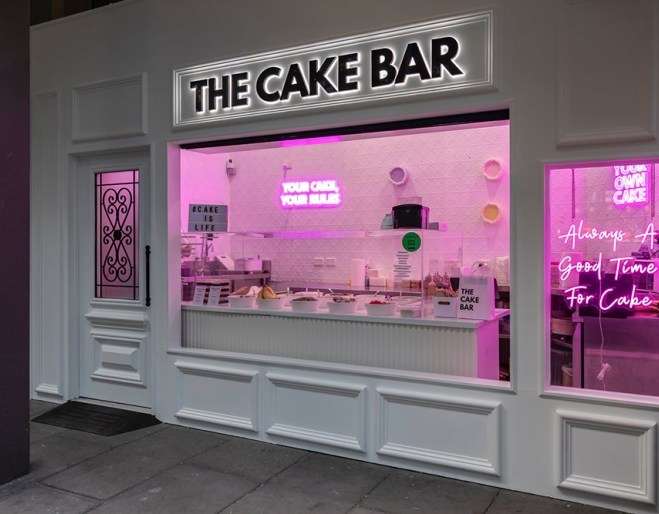 Lit up facade of The Cake Bar