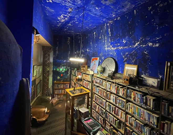 Books on shelves with blue rear wall inside The Cupboard Under The Stage, Empire Revival, Paddington
