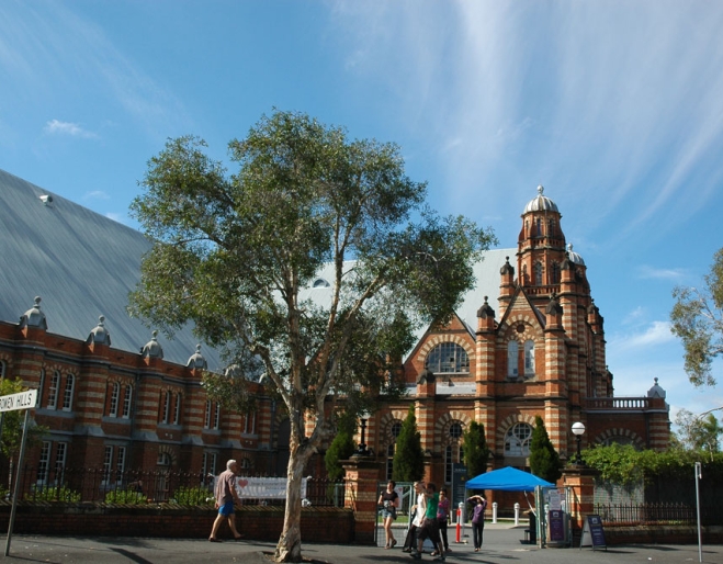 People crossing the street in front of Old Museum building in Bowen Hills Brisbane.