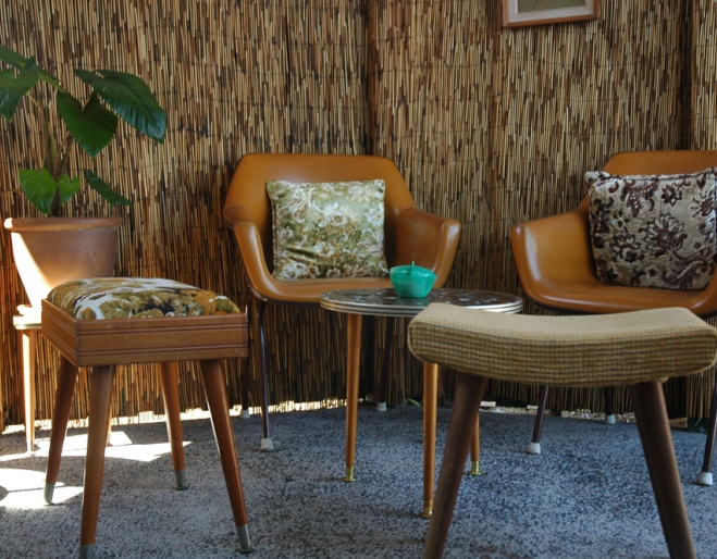 Retro furniture and bamboo screens in tiki style backyard 