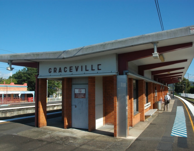 Graceville Railway Station building and platform next to train tracks.