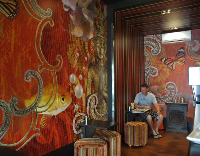 Has Beans interior with fish artwork on wall and man having coffee in Brisbane's Stones Corner