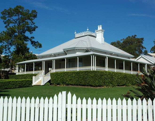 Hughesville house and front yard behind a white picket fence in Eight Mile Plains