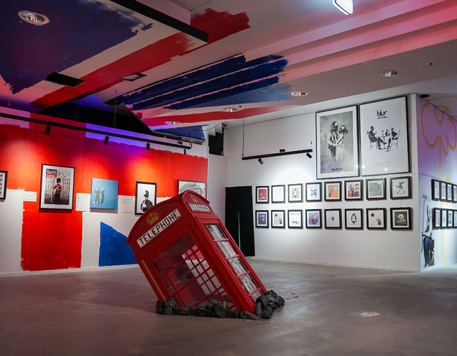 Art installation and pieces hanging on walls at The Art of Banksy Chapter 2 exhibition