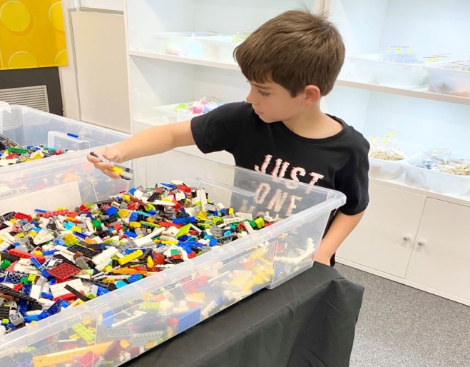 Child picking out LEGOS from box