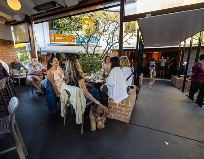 People sitting around a table with a dog at The Patio