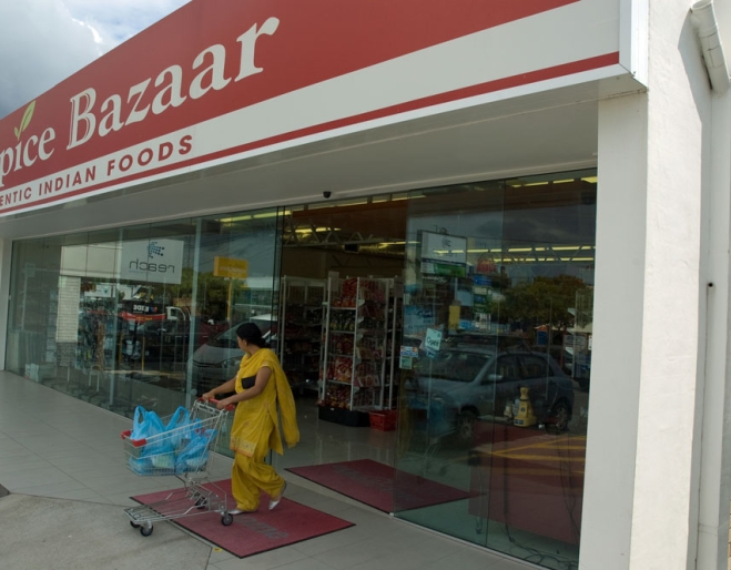 Indian woman in sari pushing tolley out of JK Spice Bazaar in Mt Gravatt