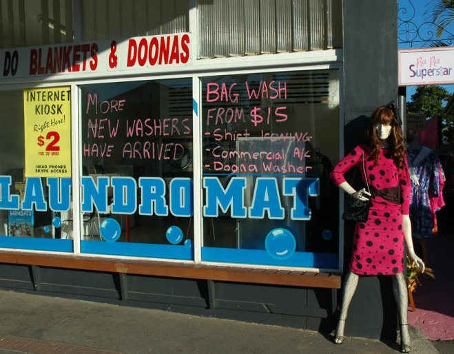 Mannequin wearing vintage dress standing outside of coin laundry shop on Given terrace next to Ra Ra Super Star