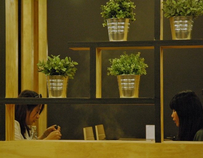 women dining at table next to potted herbs inside Shabuhouse