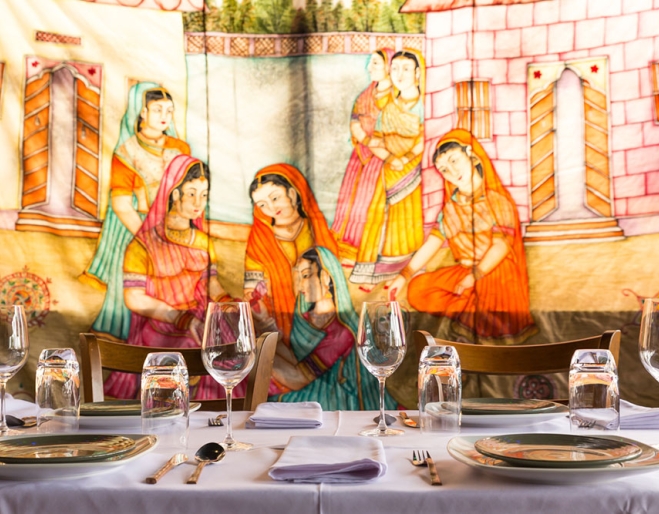 Table set for dinner at It's Mirchi Paddington with mural on wall in background