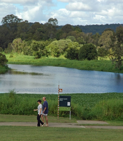 Couple walking along foot and cycle path in Minnippi Parklands next to lagoon.