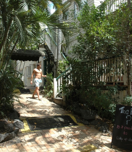Backpacker walking in lush tropical gardens of Somewhere to Stay in Highgate Hill