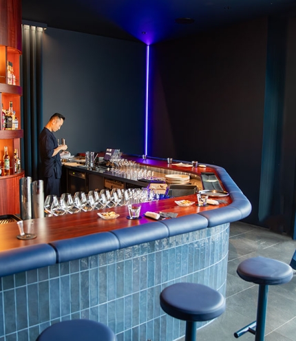 Bartenders standing behind bar in +81 Aziome Bar