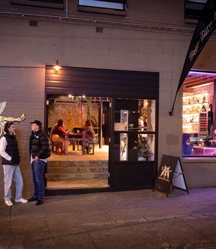 People outside Bar Mesopotamia by night
