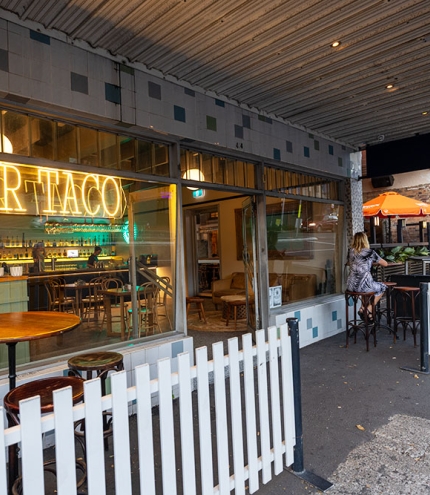 Tables outside and street entry of Bar Taco