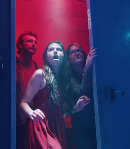 Scared people entering the doorway into Project Immersive's Area 1 Escape Rooms