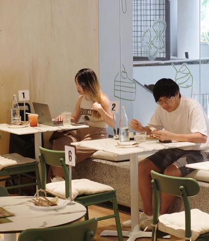 Customers sitting in window of Mitr Dessert House