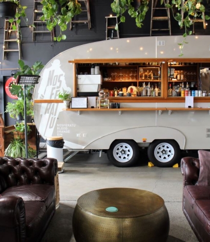 Retro caravan and two Chesterfield lounges inside Nosferatu Distillery, Bowen Hills 