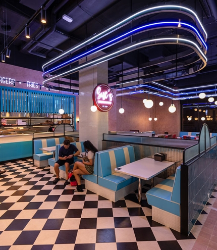 Two people sitting on a booth inside Sue's Burgers and Shakes Woolloongabba