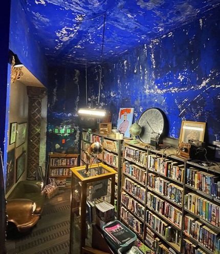 Books on shelves with blue rear wall inside The Cupboard Under The Stage, Empire Revival, Paddington
