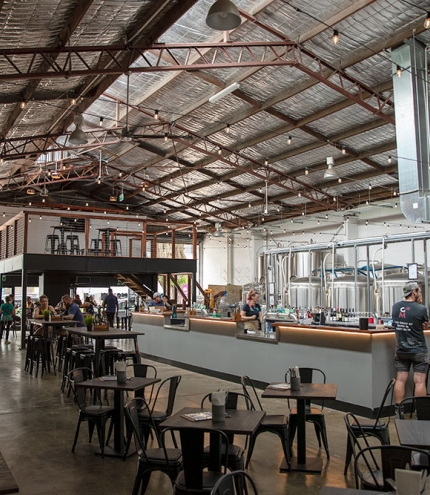 Interior of Sea Legs Brewing with people sitting at tables and standing at the bar