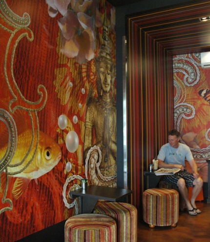 Has Beans interior with fish artwork on wall and man having coffee in Brisbane's Stones Corner