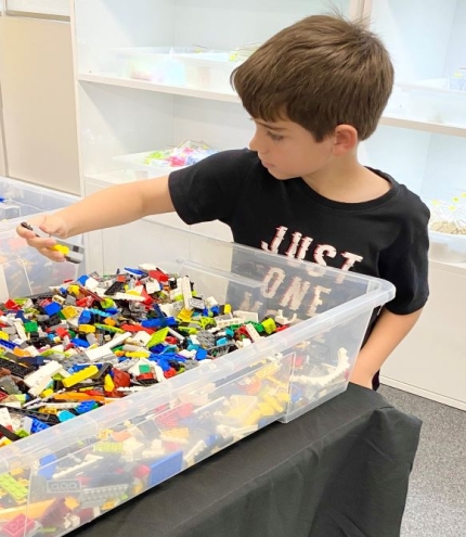 Child picking out LEGOS from box