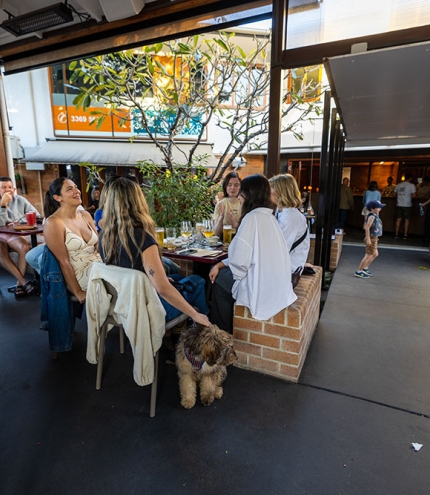 People sitting around a table with a dog at The Patio