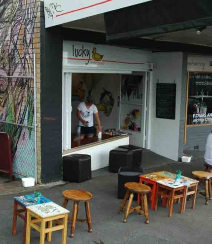 Women sitting on footpath outside Lucky Duck Espresso in Highgate Hill