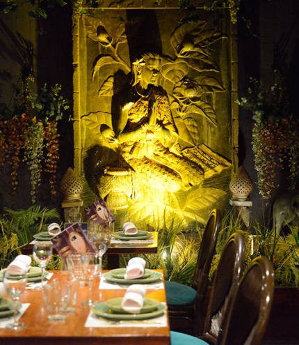 Table with Thai statue lit at night at My Thai Auchenflower